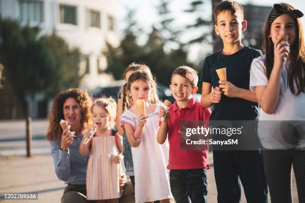 group of cheerful children eating ice-cream in summer - block party stock pictures, royalty-free photos & images