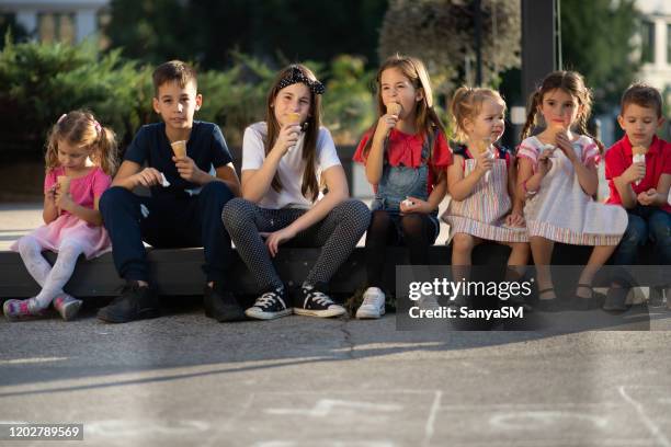 group of cheerful children eating ice-cream in summer - street party stock pictures, royalty-free photos & images