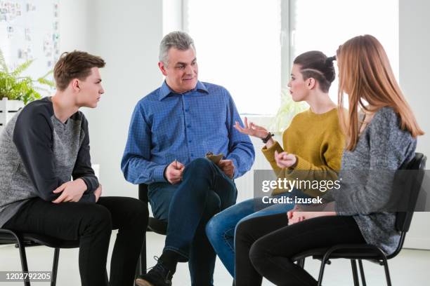 young woman gesturing during mental group therapy - low self esteem stock pictures, royalty-free photos & images