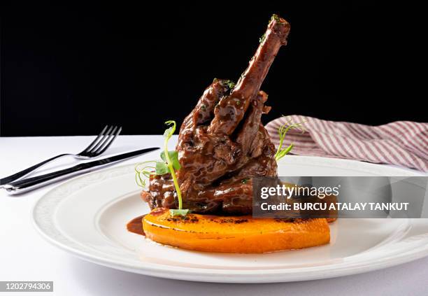 braised veal shank with roasted pumpkin - lamm fleisch stock-fotos und bilder