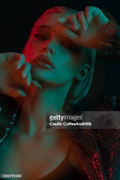 beautiful fashionable woman with multicolor highlights on her face - haze nightclub stock pictures, royalty-free photos & images