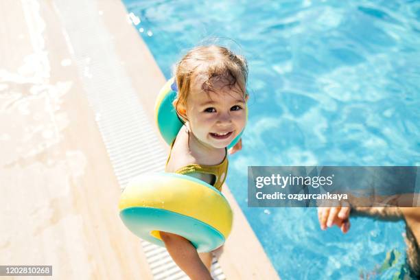 fröhliches lachen kleinkind mädchen spaß in einem schwimmbad - baby schwimmen stock-fotos und bilder