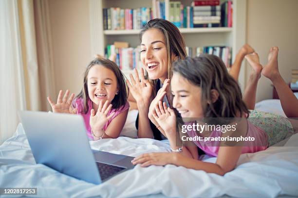 moeder en haar dochters maken videogesprek - mother daughter webcam stockfoto's en -beelden