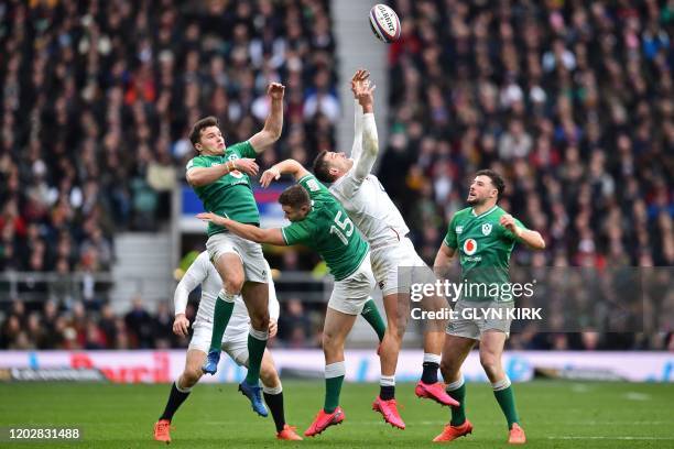 England's wing Jonny May jumps for the ball with Ireland's wing Jacob Stockdale and Ireland's full-back Jordan Larmour during the Six Nations...