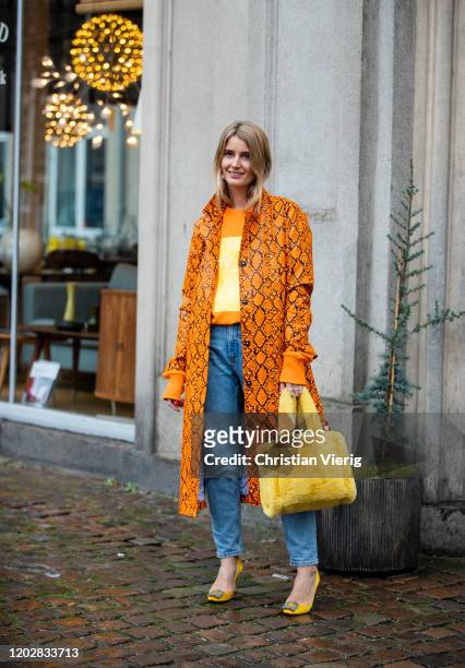 Karoline Dall seen wearing orange coat with snake print, yellow bag, denim jeans outside Custommade during Copenhagen Fashion Week Autumn/Winter 2020...