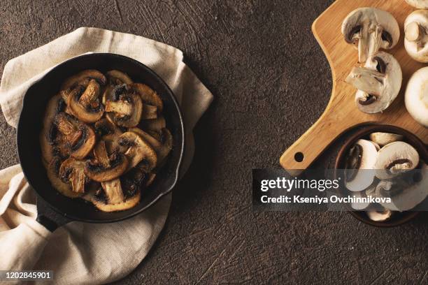 fried mushrooms in a vintage pan with fresh herbs - saute stock pictures, royalty-free photos & images