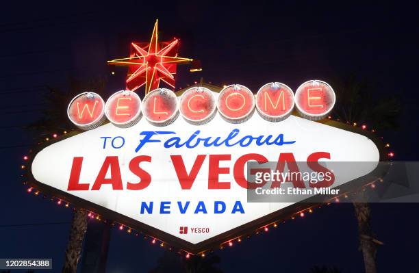 Purple and gold lights flicker around the Welcome to Fabulous Las Vegas sign as a tribute to nine victims killed in a helicopter crash on Sunday in...