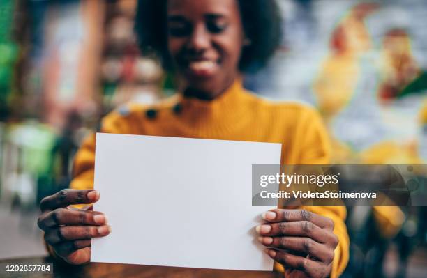 manos femeninas sosteniendo blanco vacío página de papel en blanco con espacio de copia. - black and white hands fotografías e imágenes de stock