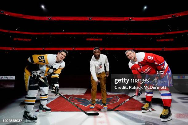 Former Washington Capitals player Joel Ward participates in a ceremonial puck drop with Sidney Crosby of the Pittsburgh Penguins and Alex Ovechkin of...