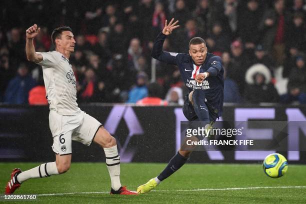 Paris Saint-Germain's French forward Kylian Mbappe shoots the ball next to Bordeaux's French defender Laurent Koscielny during the French L1 football...