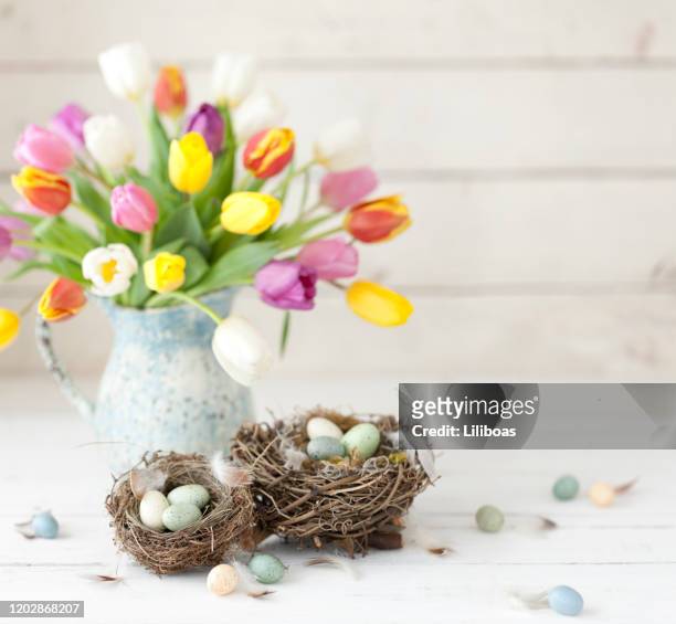 uitstekende tulpen van pasen en paaseieren op een oude witte houten achtergrond - table vase stockfoto's en -beelden
