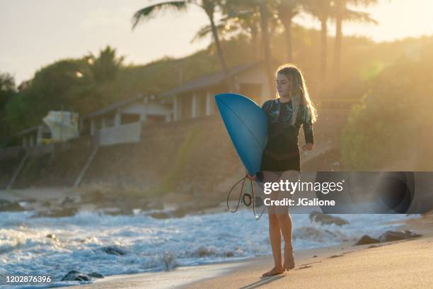 adaptive surfer walking along the beach holding a surf board - amputee girl stock pictures, royalty-free photos & images