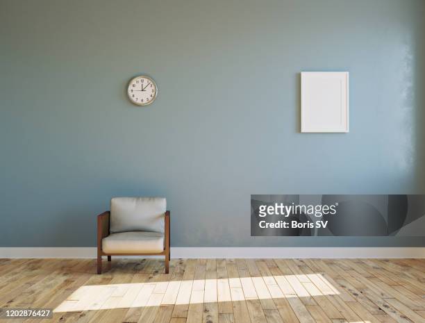 empty sunlit room with armchair and clock on the wall - wohnraum stock-fotos und bilder