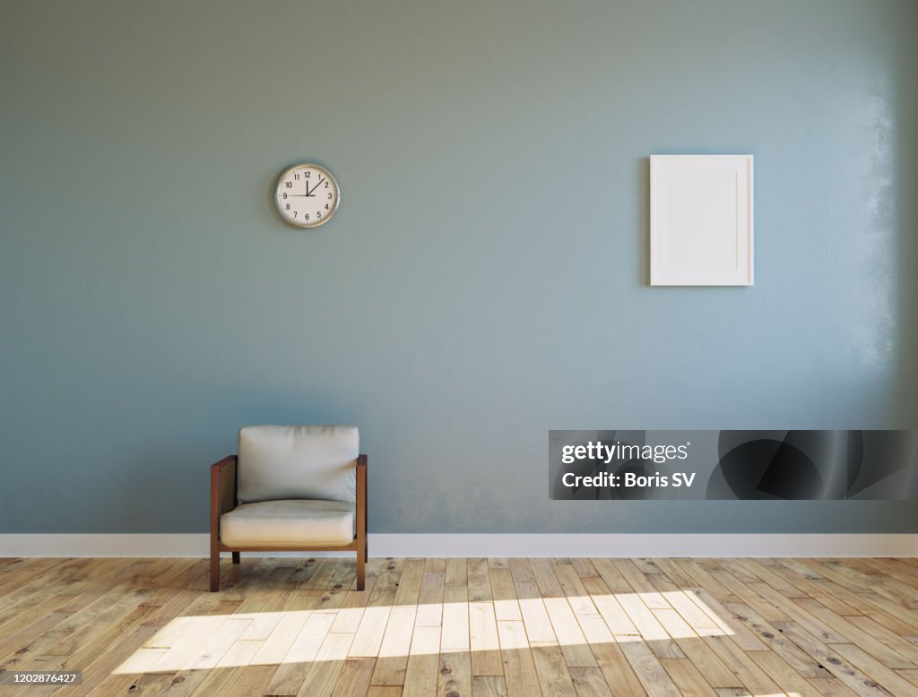 Empty sunlit room with armchair and clock on the wall