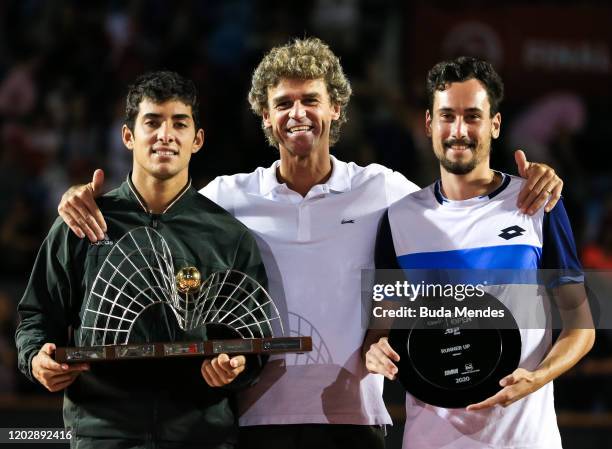 Cristian Garin of Chile and Gianluca Mager of Italy pose with the former player Gustavo Kuerten on the podium after the singles final of the ATP Rio...