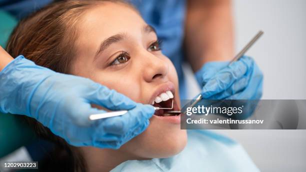 bambina che fa un esame dentistico - dentista bambini foto e immagini stock