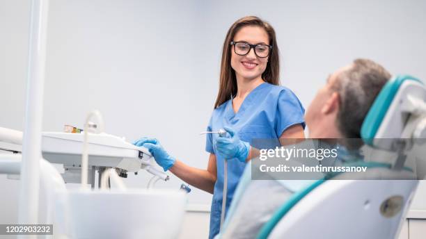 mid adult man having teeth examined at dentists - human teeth stock pictures, royalty-free photos & images