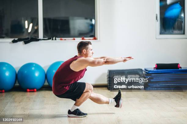 mens in een gymnastiek - op een been staan stockfoto's en -beelden
