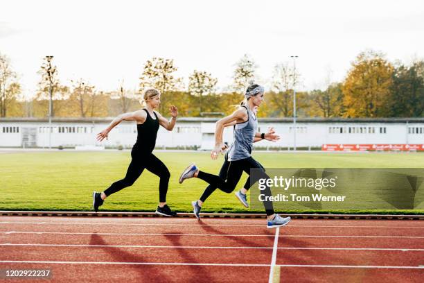 three women keeping healthy running together - pista atletica foto e immagini stock