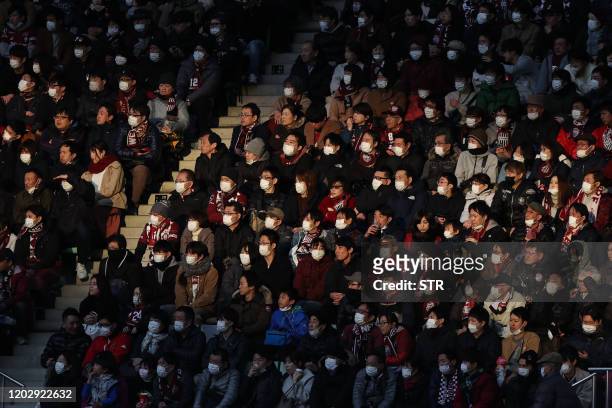 This picture taken on February 23, 2020 shows audience members wearing face masks at a J.League football match between Vissel Kobe and Yokohama F....