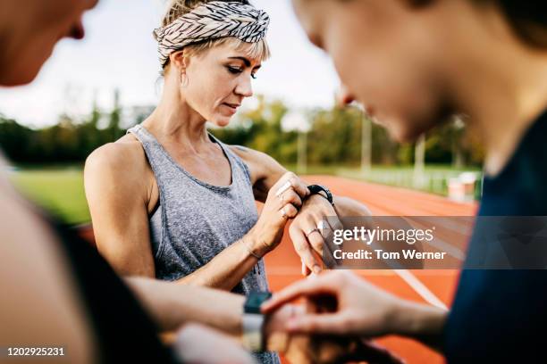 fitness enthusiasts checking their times after a run - train tracks stockfoto's en -beelden