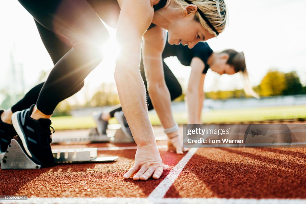Close Up Of Women At Starting Blocks On Outdoor Track