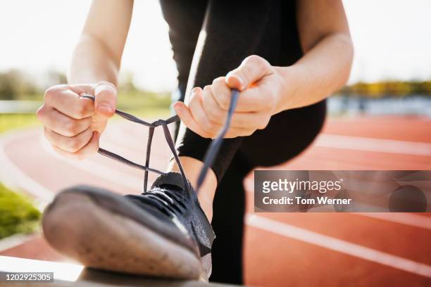 close up of runner tying shoelaces - amarrar o cadarço - fotografias e filmes do acervo