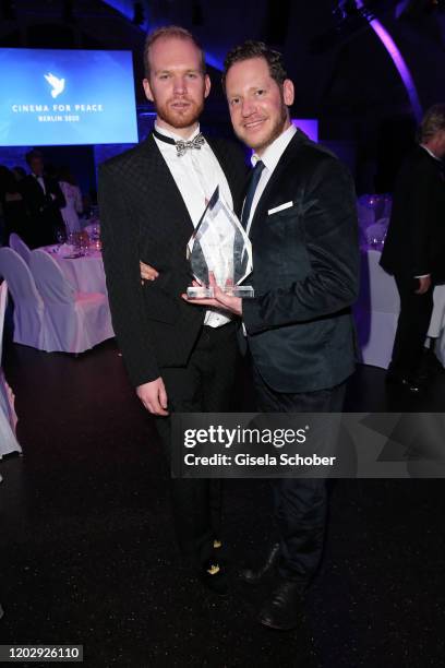 Director Marco Kreuzpaintner and his partner Owen Petty with award during the Cinema For Peace Gala at Westhafen Event & Convention Center on...