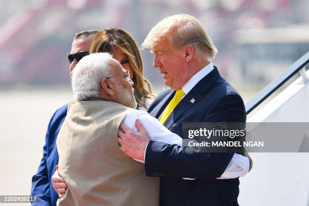 India's Prime Minister Narendra Modi embraces US President Donald Trump upon his arrival at Sardar Vallabhbhai Patel International Airport in...