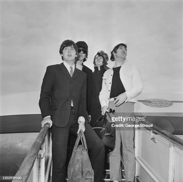 From left, Paul McCartney, George Harrison , Ringo Starr and John Lennon of English pop group The Beatles stand on the steps of their Iberia aircraft...