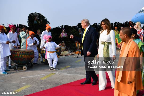 President Donald Trump and First Lady Melania Trump are greeted by performers wearing traditional costumes as they arrive at Agra Air Base in Agra on...