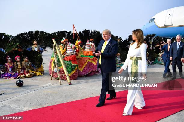 President Donald Trump and First Lady Melania Trump are greeted by performers wearing traditional costumes as they arrive at Agra Air Base in Agra on...