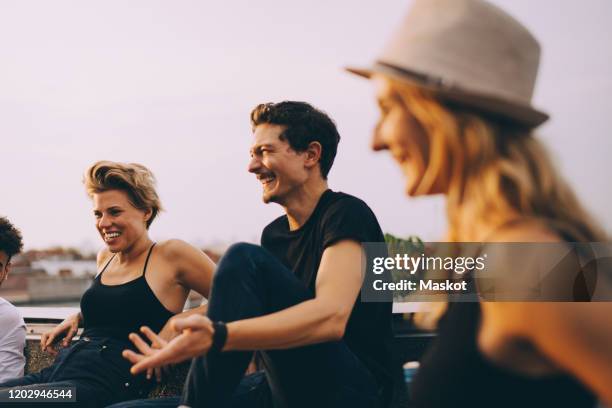 cheerful friends having fun at rooftop party during dusk - rooftop deck stock pictures, royalty-free photos & images