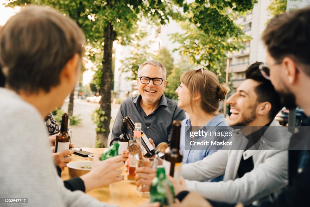 Portrait of happy mature male sitting with friends and enjoying at social gathering