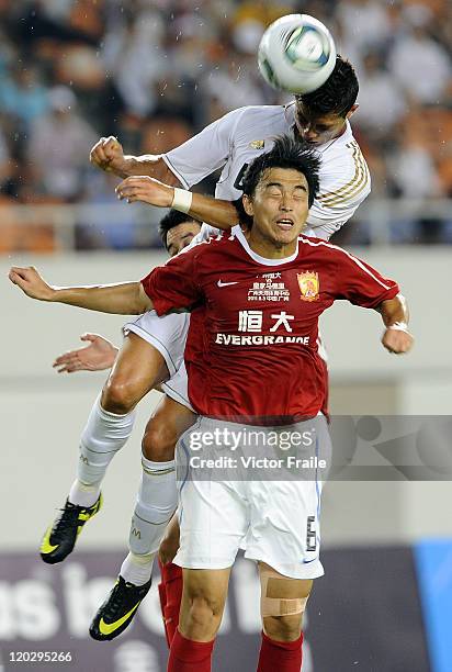 Cristiano Ronaldo of Real Madrid and Feng Xiaoting of Guangzhou Evergrande jumps for the ball during the pre-season friendly match between Guangzhou...