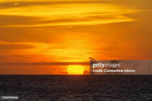 sun setting on sea horizon at golden hour sunset - kota kinabalu beach stock pictures, royalty-free photos & images