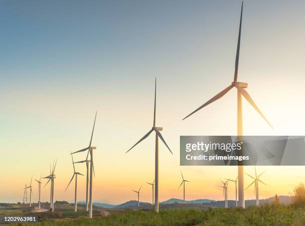 natuur windturbines en zonnepanelen met hoogspanningsstroom voor schone energie in bergen - wind farms stockfoto's en -beelden