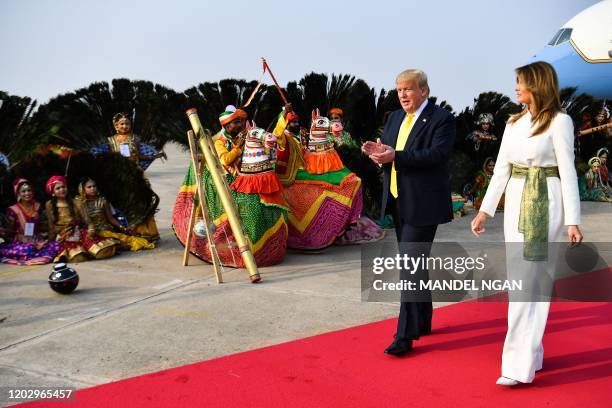 President Donald Trump and First Lady Melania Trump are greeted by performers wearing traditional costumes as they arrive at Agra Air Base in Agra on...