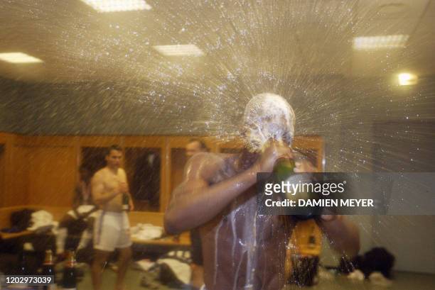 L'attaquant d'Auxerre Djibril Cissé célèbre la victoire de son club au champagne dans les vestiaires du stade de France, le 31 mai 2003, à l'issue du...