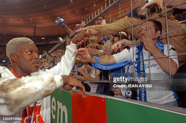 L'attaquant d'Auxerre Djibril Cissé salue ses supporteurs, le 31 mai 2003 au Stade de France à Saint-Denis, après avoir remporté 2 à 1 la finale de...