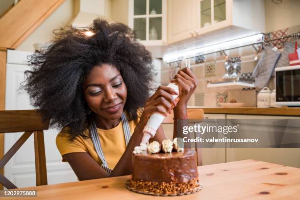 afro women decorating a cake at home - decorar um bolo imagens e fotografias de stock