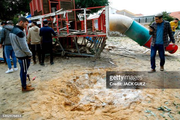 People inspect damage at a kindergarten in the southern Israeli city of Sderot, near the border with the northern Gaza Strip, on February 24...
