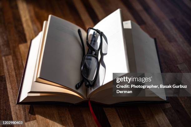 book and reading glasses - thick reading glasses stock pictures, royalty-free photos & images