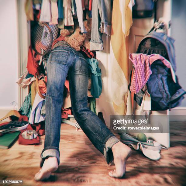 mujer buscando en un armario desordenado. - placard fotografías e imágenes de stock