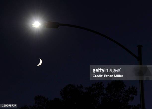 Waxing crescent moon is seen behind a streetlight with a newly-installed LED fixture August 3, 2011 in Las Vegas, Nevada. The city is replacing 6,600...