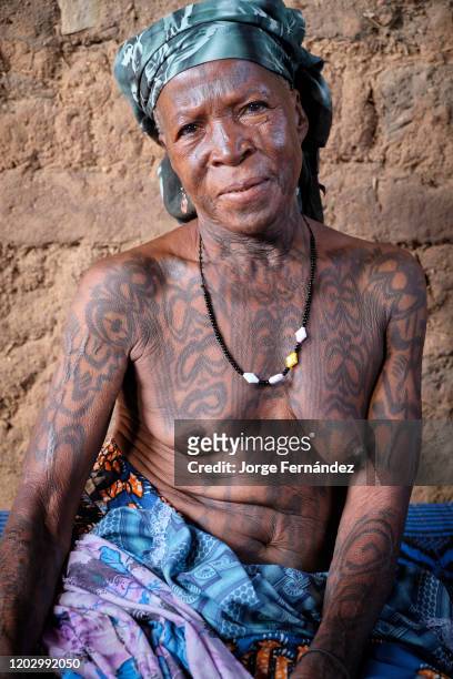 Portrait of a middle aged Dukkawa woman heavily tattooed over her body.