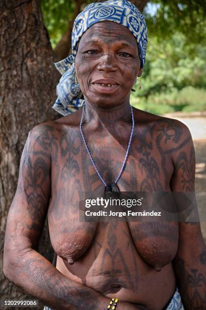 Portrait of a middle aged Dukkawa woman heavily tattooed over her body.