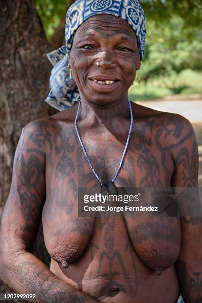Portrait of a middle aged Dukkawa woman heavily tattooed over her body.