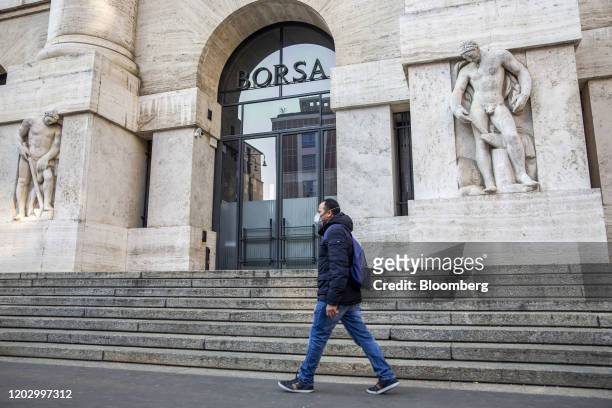 Pedestrian wearing a protective face masks passes the Milan Stock Exchange in Milan, Italy, on Monday, Feb. 24, 2020. Stunned by Europe's biggest...