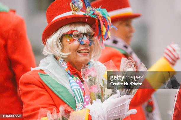 Member of Rose Monday Parade throws the flower to the crowd during the Rose Monday parade on February 24, 2020 in Cologne, Germany.